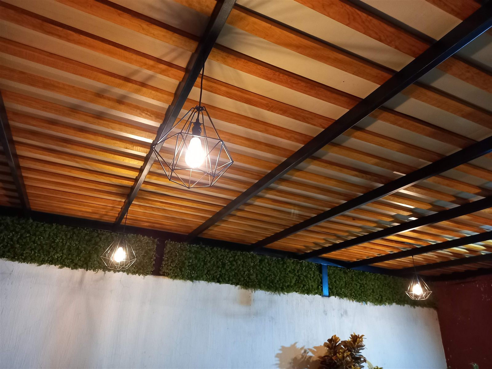 Pérgola de duela de madera con lámpara geométrica de noche