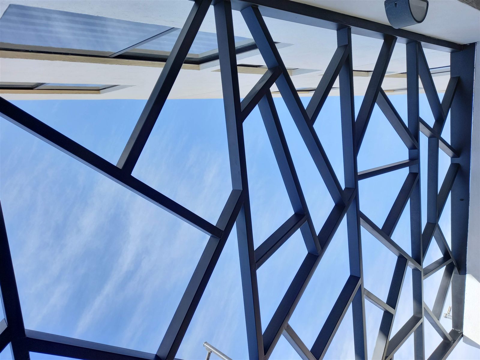Techo de cristal con estructura geométrica contra el cielo