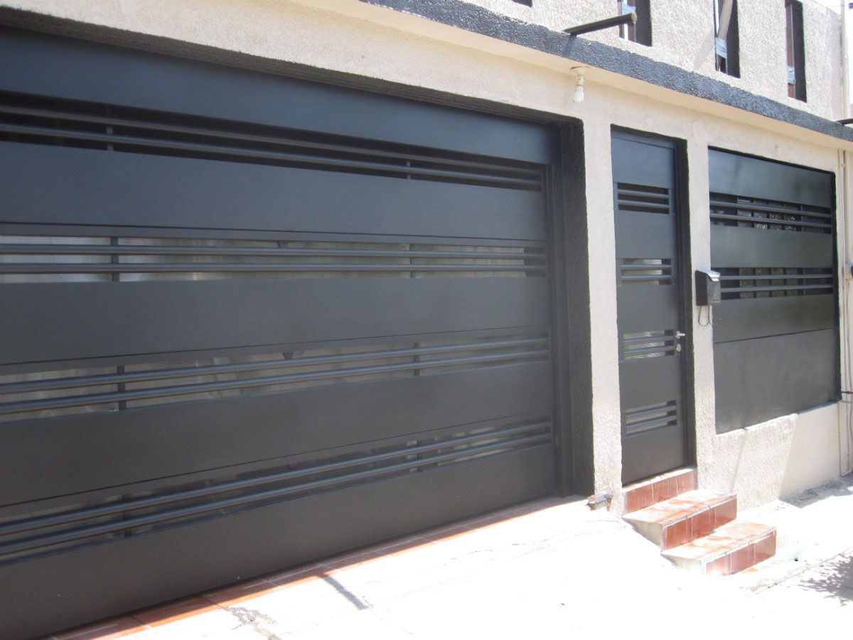 Portón negro de lámina con puerta peatonal integrada