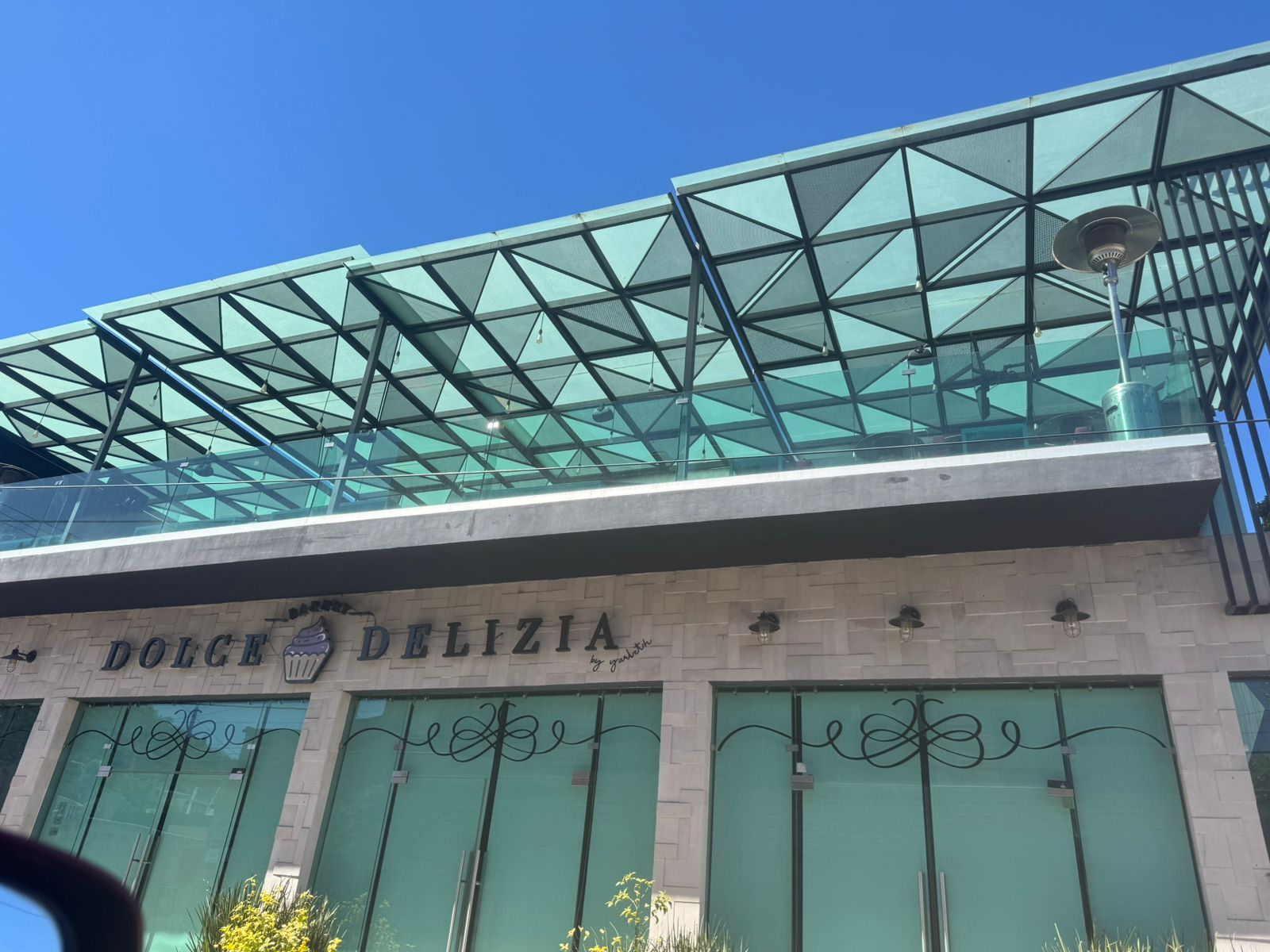 Pérgola voladiza de acero sin postes al frente, anclada por completo al muro
