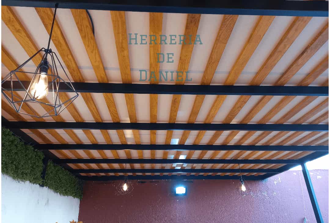 Pérgola con estructura de acero, travesaños de madera y cubierta de lona